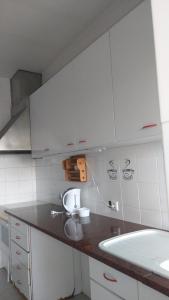 una cocina con armarios blancos y fregadero en Quinta do Lago Verde, en Coruche
