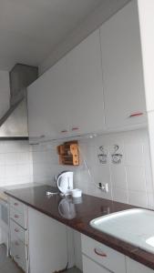 Una cocina con gabinetes blancos y un fregadero. en Quinta do Lago Verde, en Coruche