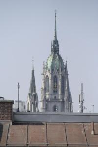 um edifício com uma torre de relógio ao fundo em Hotel Demas City em Munique
