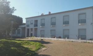 Un edificio blanco con balcones a los lados. en Quinta do Lago Verde, en Coruche