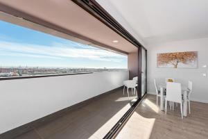 a dining room with white walls and a large window at Stay U-nique Apartment Louis Pasteur in Málaga