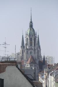 une église avec une tour d'horloge au-dessus d'un bâtiment dans l'établissement Hotel Demas City, à Munich