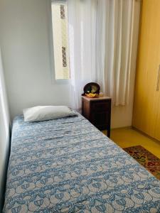 a bedroom with a bed and a table and a window at Quarto Morumbi - Somente Mulheres in Sao Paulo