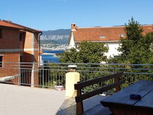 einen Balkon mit einer Bank und Blick auf das Wasser in der Unterkunft Apartments Rea in Šilo
