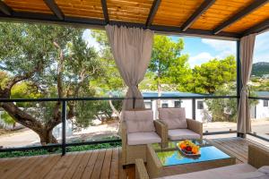 a screened in porch with a couch and a table at CAMP ADRIATIC MOBILE HOMES - PRIMOŠTEN in Primošten