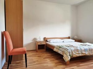 ein Schlafzimmer mit einem Bett und einem Stuhl in der Unterkunft Apartments Rea in Šilo