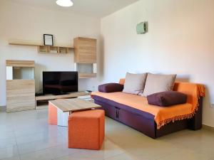 ein Wohnzimmer mit einem Sofa und einem Flachbild-TV in der Unterkunft Apartments Rea in Šilo