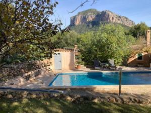 a house with a swimming pool with a mountain in the background at Sa Sort de Can Moix in Alaró
