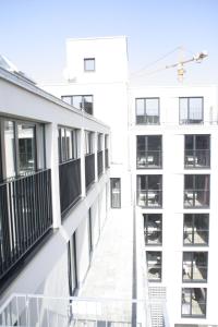 Habitación con balcón y vistas al exterior de un edificio blanco. en Hotel Demas City, en Múnich