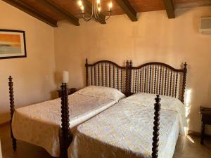 a bedroom with two beds and a chandelier at Sa Sort de Can Moix in Alaró