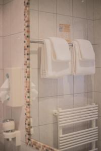 a bathroom with a shower with white towels at Landhotel Postgut - Tradition seit 1549 in Tweng