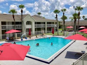 una piscina en un complejo con gente dentro en Pool - WiFi - Gym - Parking - Best Location ! en Kissimmee