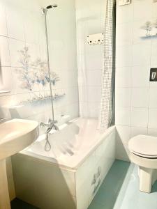 baño blanco con bañera y aseo en Appartamento - Residence I Larici en Folgarida