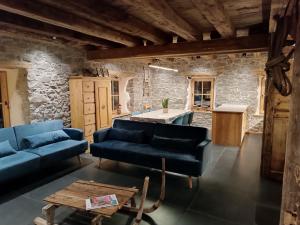 a living room with blue couches and a table at Brand new Duplex in the Dolomites - Picchio Rosso in Rocca Pietore