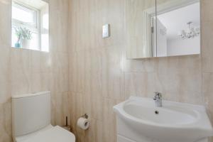 a white bathroom with a toilet and a sink at Room in Guest room - Family room with private bathroom in Edgware