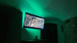 TV de pantalla plana en una habitación con luz verde en Cueva Ramón, en Guadix