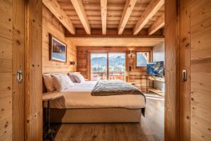 a bedroom with a bed in a room with a window at Chalet Heavenly Morzine - by EMERALD STAY in Montriond