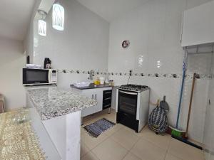 uma cozinha branca com um fogão e um lavatório em Apto novo, mobiliado e acochegante em Boa Vista