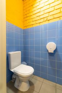 La salle de bains est pourvue de toilettes et de carrelage bleu. dans l'établissement ololoFreelander Hostel&Coworking, à Bishkek