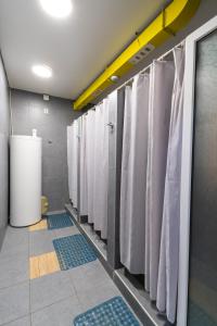 a row of white shower stalls in a bathroom at ololoFreelander Hostel&Coworking in Bishkek