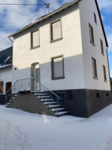 a building with stairs in the snow in front of it at Ferienhaus Gartenblick in Brieden in Brieden