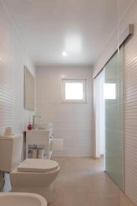 uma casa de banho branca com um WC e um lavatório em Barra Beach House 2 em Gafanha da Nazaré