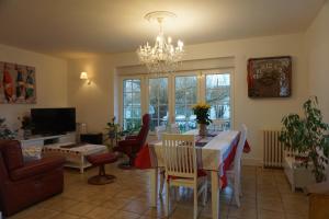 sala de estar con mesa de comedor y lámpara de araña. en ARVEIL en Plomeur