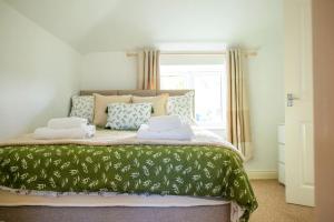 a bedroom with a bed with two pillows on it at Laburnum Maisonettes by Oracle in Stratford-upon-Avon