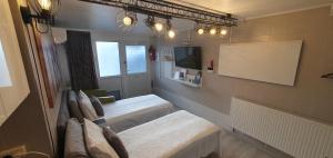 a small room with two beds and a tv at ApartHotel SAVAS 1 Mini Studio and parking in Kaunas +13 photos