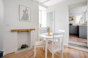 a white dining room with a white table and chairs at Cosy cottage near the coast in Tywardreath