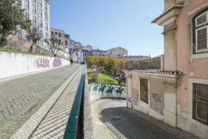 una strada con graffiti sul lato di un edificio di Duplex in Lisbon old town, 321 a Lisbona