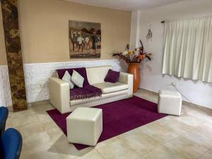 a living room with a white couch and a purple rug at PATASTAY in San Salvador de Jujuy