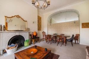 a living room with a table and a fireplace at Green Park in Bath