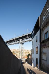 een brug in het midden van een straat met een gebouw bij Oh! Porto - Whole Property in Vila Nova de Gaia