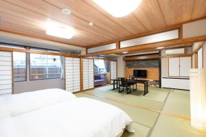 a bedroom with a bed and a dining room at Arimakan in Kaminoyama