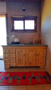 d'une cuisine avec des placards en bois, un évier et une fenêtre. dans l'établissement AMARRA Camet Norte, à Santa Clara del Mar