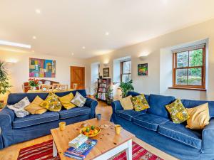 a living room with blue couches and a wooden table at 2 Bed in Coldingham 93242 in Duns