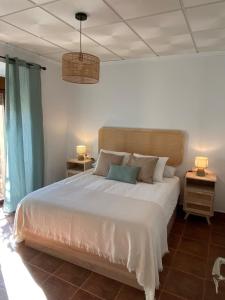 a bedroom with a large white bed with two night stands at Balcón de la Plaza in Moclín