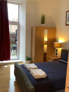 a bedroom with a bed with two towels on it at Ground Floor Apartment with Garden in Glasgow