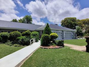 a house with a tree in the front yard at Nauntons Guest House & Wedding Venue in Ladysmith