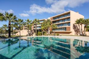 une piscine en face d'un bâtiment dans l'établissement TAC - Salgados Beach Prime Pool Resort, à Guia