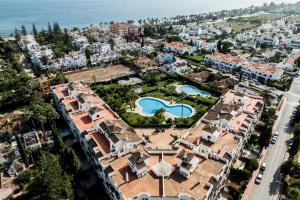 マルベーリャにあるModern Coastal Apartment Near Puerto Banúsの2つのプール付きの街の空中ビュー