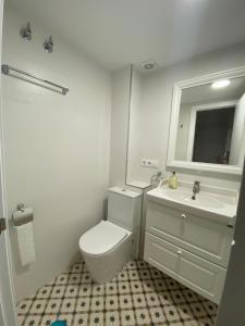 a bathroom with a white toilet and a sink at Apartamento Fernández Ladreda in Cádiz