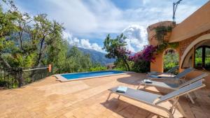 a patio with chairs and a swimming pool at Sol y Montes in Fornalutx