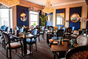 um restaurante com mesas e cadeiras numa sala com paredes azuis em Llandudno Bay Hotel em Llandudno