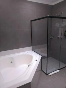 a bathroom with a tub and a glass shower at Transamerica Araraquara in Araraquara