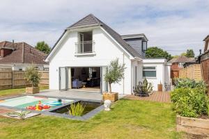 a white house with a swimming pool in the yard at Luxury, eco-friendly 3 bed haven with plunge pool - Riverway Retreat Lux in Christchurch