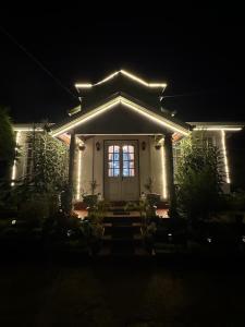 a house with lights on the front of it at night at Princess Bungalows in Nuwara Eliya