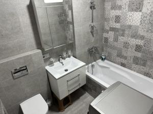 a bathroom with a sink and a toilet and a tub at RS apartment in Batumi +18 photos