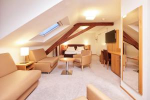 ein Zimmer mit einem Wohnzimmer und einem Esszimmer in der Unterkunft Central City Hotel Rochat in Basel